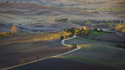 An aerial shot of a field and hills under the sunlight